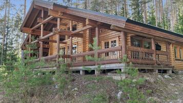 A log cabin with a porch and multiple windows.