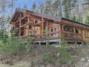 Eine Blockhütte mit Veranda und zahlreichen Fenstern.