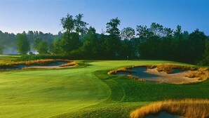 A golf course with sand bunkers, a flagstick, and a clear sky. - Spacious, Cozy 5 Bedroom Compound  (Saratoga Springs)