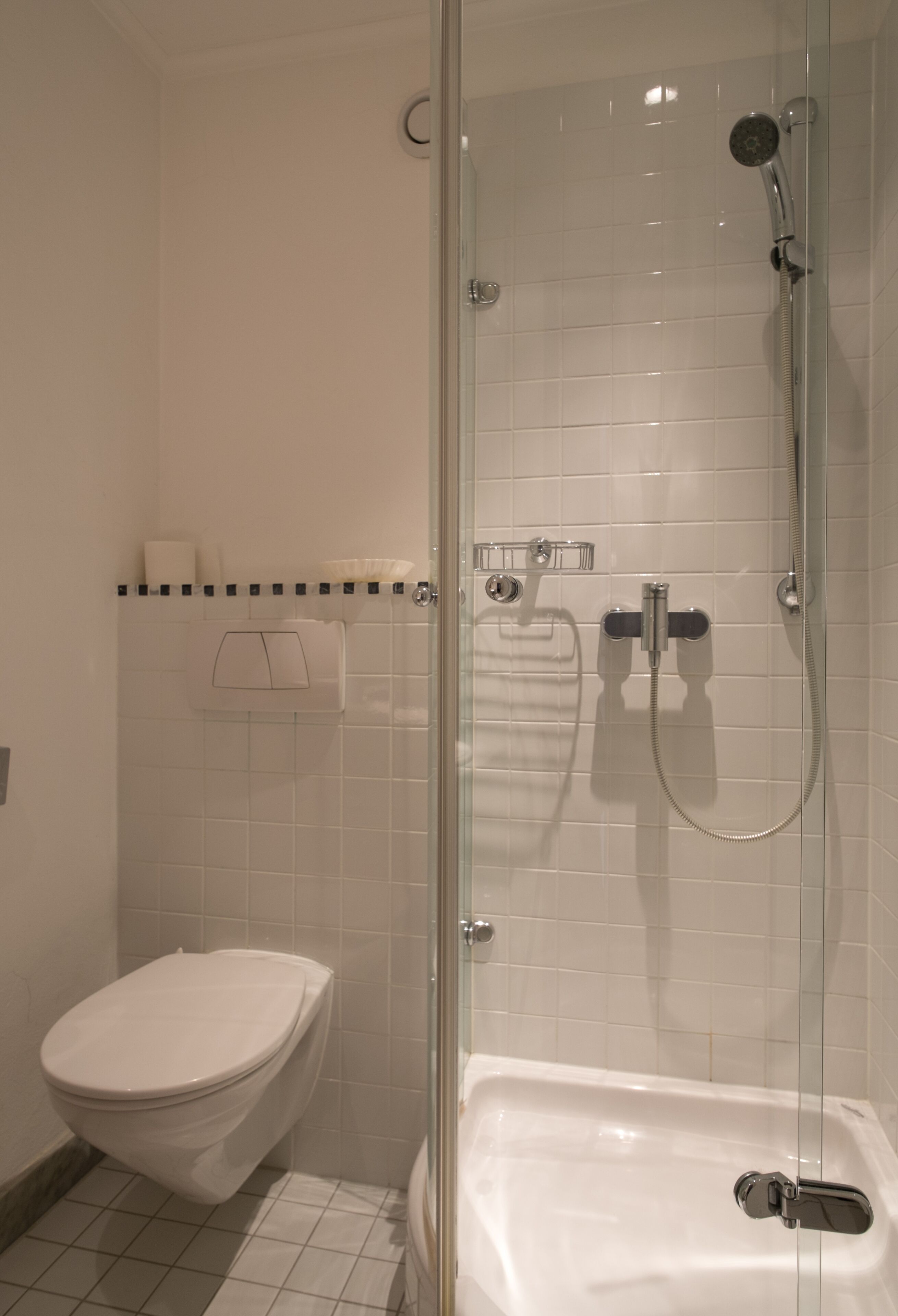 Une salle de bain moderne avec une douche à parois de verre, des toilettes blanches et une baignoire.
