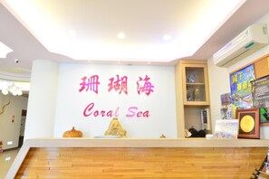 Un espace d’accueil avec une enseigne indiquant « Coral Sea » en chinois et en anglais.