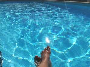 A clear view of a swimming pool with visible ripples on the water surface.