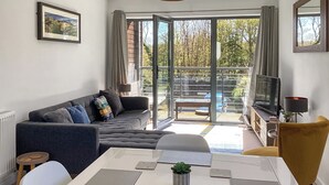 Una sala moderna con un sofá, una mesa de comedor y un televisor.