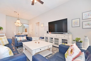 Relax in this stylish living room with a large flat-screen TV, comfortable sofa, and a coffee table.