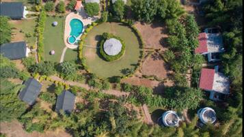 Vista aérea de una zona residencial con piscina, jardín circular y varios edificios.