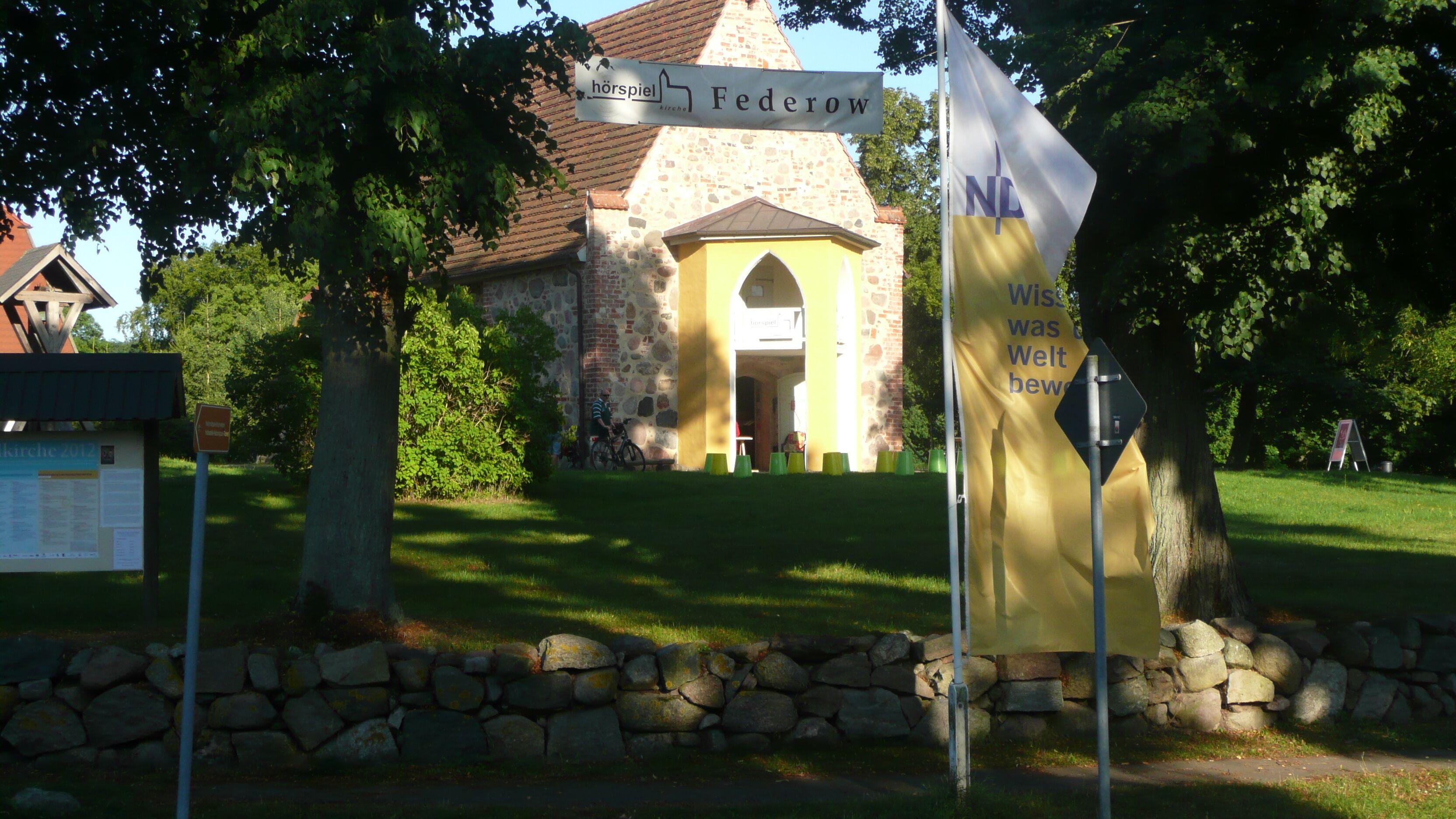 A church with a stone facade and a yellow entrance.