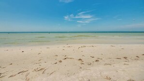 Ein Strand mit klarem Wasser und sandigem Ufer.