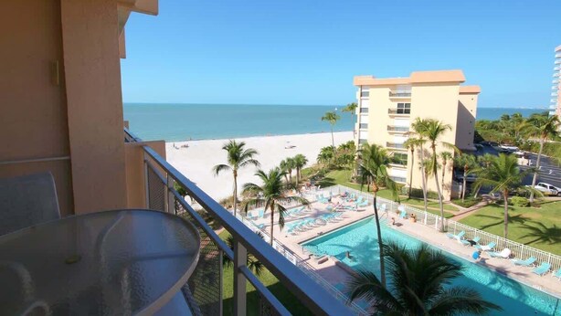 Ein Balkon mit Blick auf Strand und Poolbereich.
