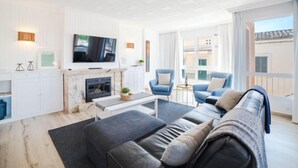 Una sala de estar moderna con chimenea, televisor de pantalla plana y asientos cómodos.