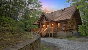 A log cabin with a wooden deck and a staircase leading to the entrance. - Ridge Views - 2BR/New Hot Tub/New Firepit/Grill/Sleeps 8 (Gatlinburg)