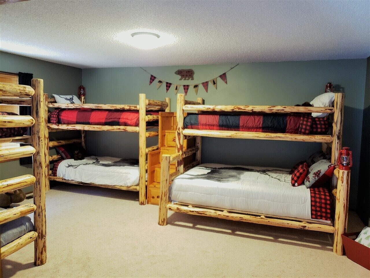 A room with two bunk beds, wooden furniture, and a small ladder.