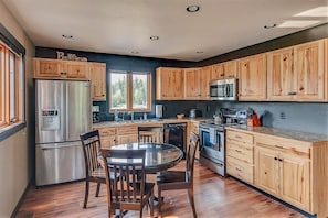 Enjoy cooking in this kitchen with a central island, stainless steel appliances, and wooden cabinetry.