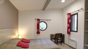 Une chambre à coucher avec un lit, une chaise, une fenêtre et un radiateur.