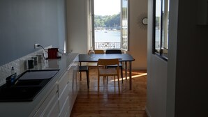 Eine kompakte Küche mit Essbereich, Blick auf das Wasser und einem Balkon.
