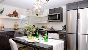 Una cucina moderna con un tavolo da pranzo, sedie, un frigorifero, un forno a microonde e diversi elettrodomestici.