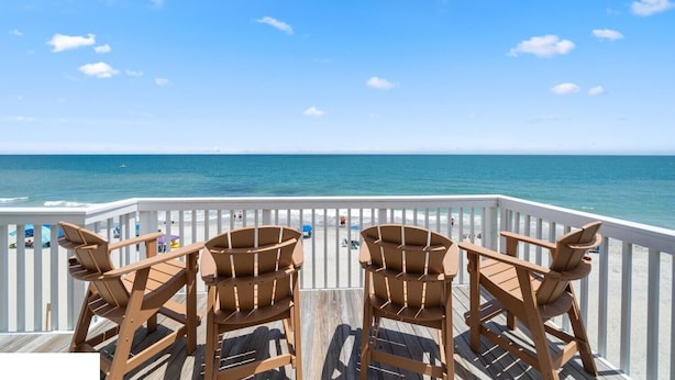 A wooden deck with two chairs facing a beach. - Take It E-Sea | Oceanfront + Community Pool! (Kure Beach)