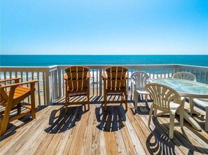 A wooden deck with outdoor furniture overlooking a beach. - Take It E-Sea | Oceanfront + Community Pool! (Kure Beach)