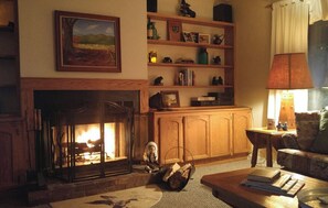 Cozy living room with a fireplace, comfortable sofa, and warm ambiance.