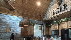Une cuisine rustique avec des meubles en bois, un îlot central et une décoration sur le thème des ours.