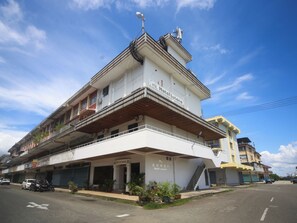 A hotel with a prominent balcony, a staircase leading to the entrance, and a clear sky. - Super OYO 1026 Hotel Lutana (Sandakan)