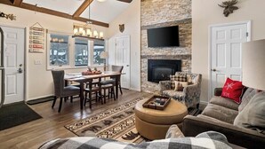 Amplia sala de estar con chimenea, comedor y cocina.