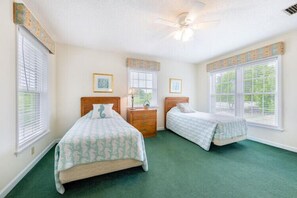 A bedroom with two beds, a dresser, and a ceiling fan. - The Colman at Ships Watch in Duck (Duck)