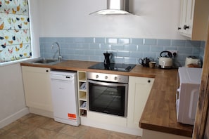 Enjoy cooking in this well-equipped kitchen with a dishwasher, oven, and coffee maker.