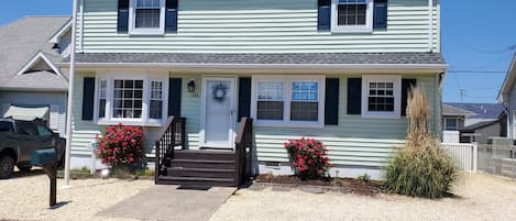 A two-story house with a front porch, a mailbox, and a 'For Rent' sign.