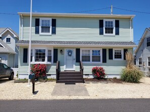 A two-story house with a front porch, a mailbox, and a 'For Rent' sign.