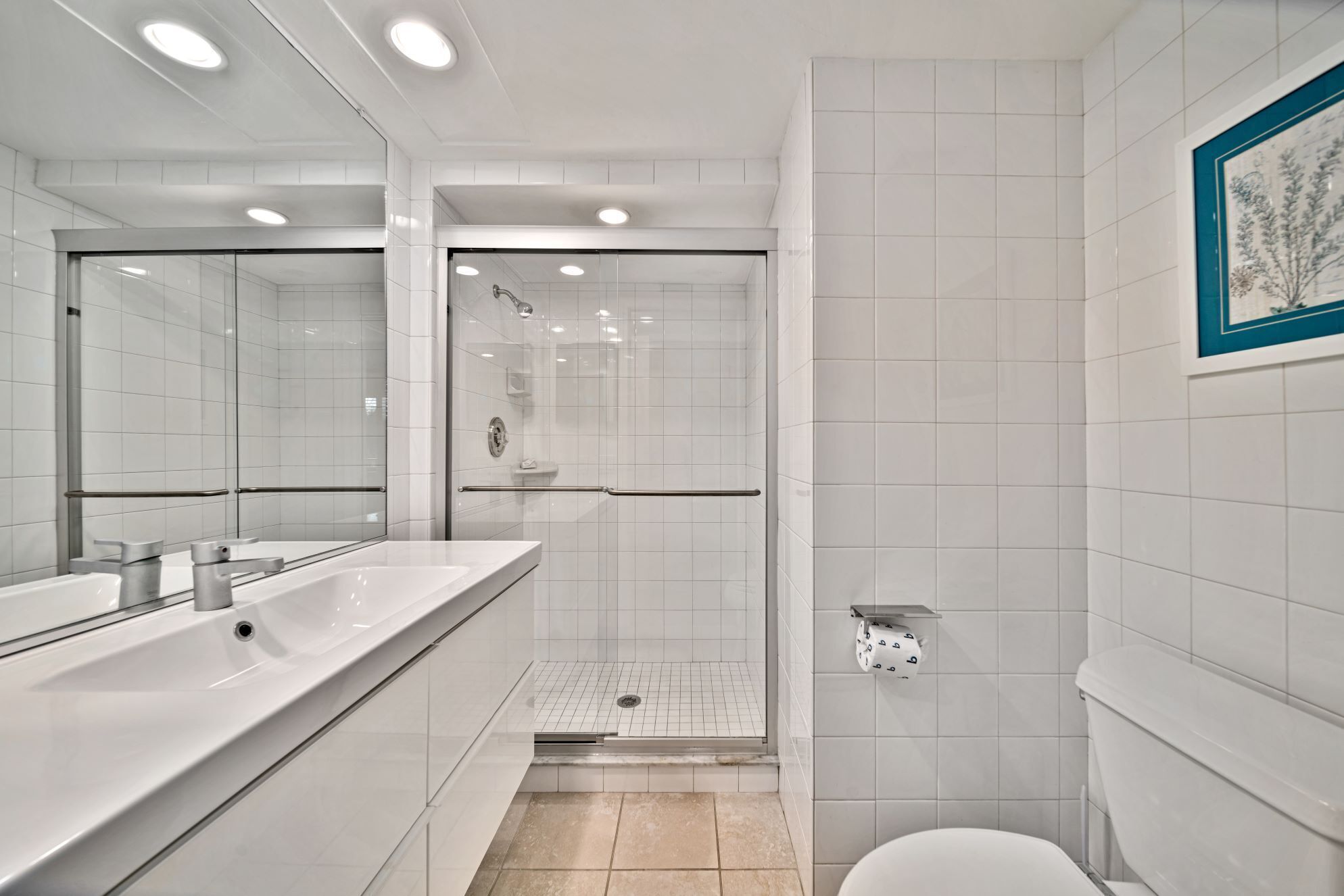 A modern bathroom with a glass-enclosed shower, a large mirror, and a toilet.