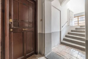 A wooden door, a white wall, and a stone staircase.