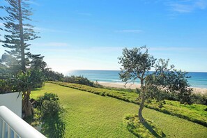 Una zona erbosa con vista sull'oceano e su una spiaggia.