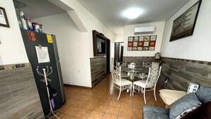 A compact living space with a dining area, a sofa, a TV, and a refrigerator. - Charming little house in Tlaquepaque (San Juan)