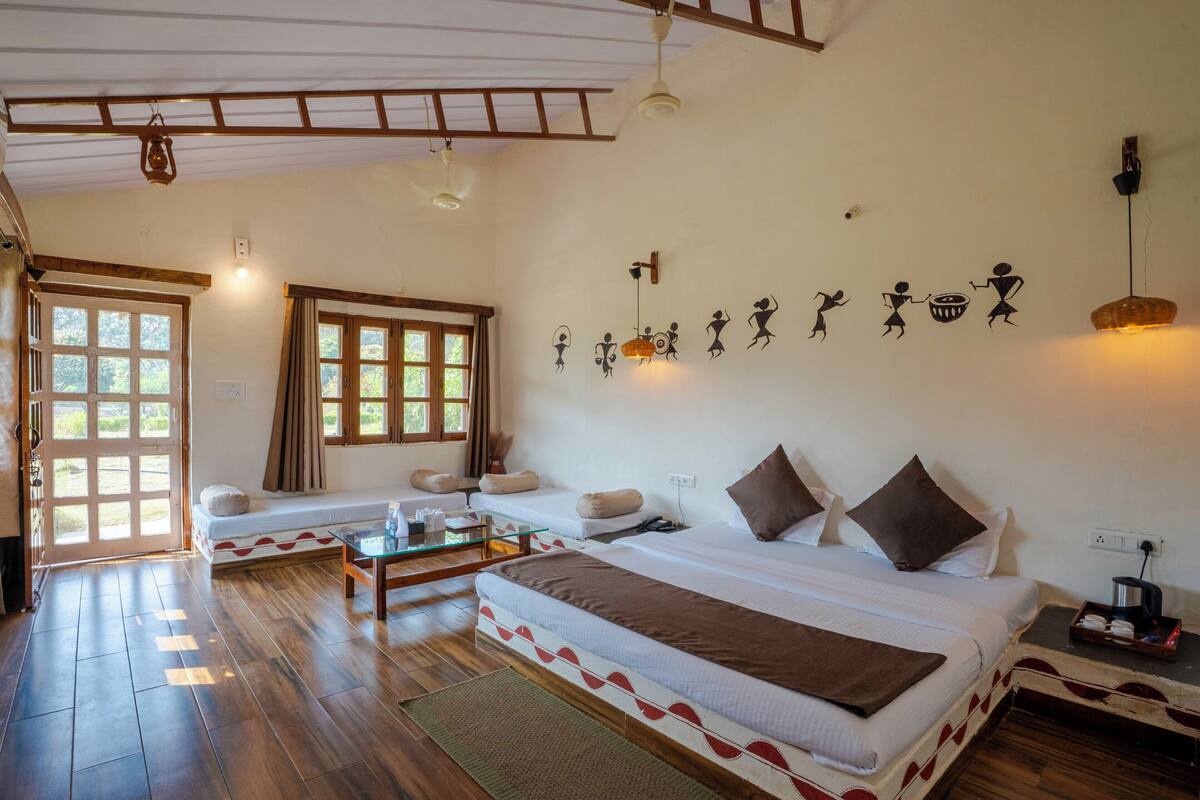 A room with two beds, a glass coffee table, and a large window.
