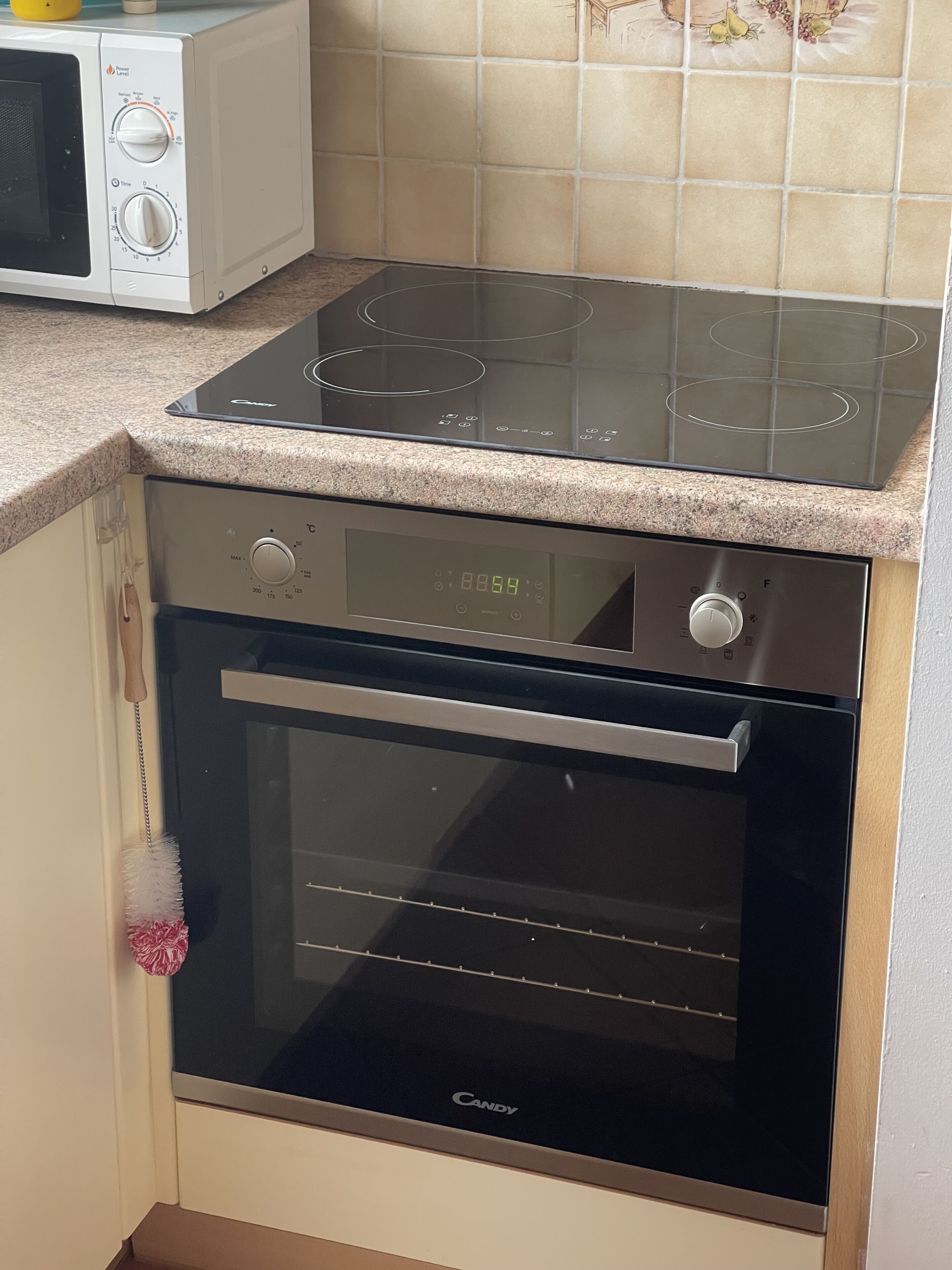 A kitchen with a built-in oven and microwave.