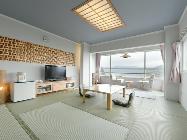 A modern living room with a television, wooden cabinet, and tatami mats. - Hotel Ra Kuun (Hakone)