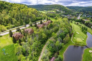 Un complexe hôtelier comprenant plusieurs bâtiments, un terrain de golf et un lac.