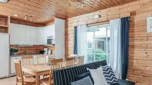 A cozy cabin with a dining area, kitchen, and a sofa with patterned cushions. - Vacation home B by Interhome (Porvoo)