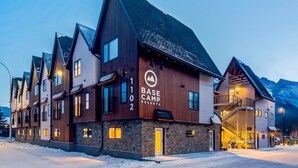 Una cabaña de varios pisos con diseño rústico, que presenta un cartel llamativo de Base Camp Resorts.