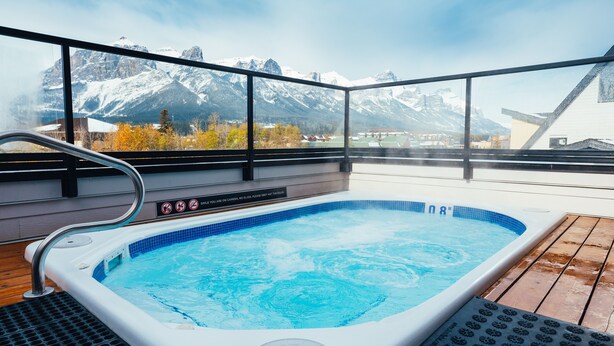 Un jacuzzi con vistas a montañas nevadas.