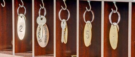 A key rack with numbered keys and a sign above stating, "If you want breakfast in bed, sleep in the kitchen."