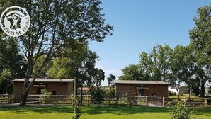 A rural setting with two wooden cabins surrounded by a wooden fence, a grassy field, and trees. - Modern chalet 4-6 ppl, pets allowed, private terrace (Veauchette)