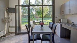 A modern kitchen with a dining area, large windows, and a view of the outdoors. - Modern chalet 4-6 ppl, pets allowed, private terrace (Veauchette)