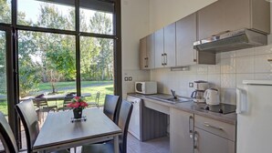 A modern kitchen with a dining area, large windows, and a view of the outdoors. - Modern chalet 4-6 ppl, pets allowed, private terrace (Veauchette)