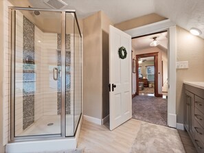 Experience a comfortable living space with a glass-enclosed shower and a cozy fireplace.