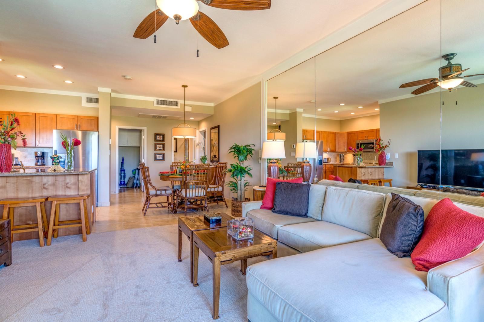 A spacious living room with a large sofa, wooden coffee table, and a dining area with a wooden table and chairs.