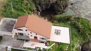 Ein modernes Haus mit Satteldach, einer kleinen angeschlossenen Garage und einem gepflasterten Einfahrt.