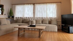 Ein Wohnzimmer mit einer Couch, einem Couchtisch und einem Fernseher.