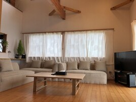 Una sala de estar con sofá, mesa de centro y televisor.