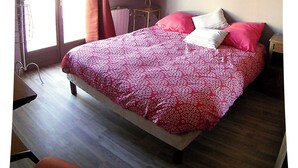 A bedroom with a large bed, a chandelier, a painting on the wall, and a window with curtains. - Promotions to seize: Beautiful artist cottage, private pool, exceptional view (Peyrefitte-sur-l'Hers)